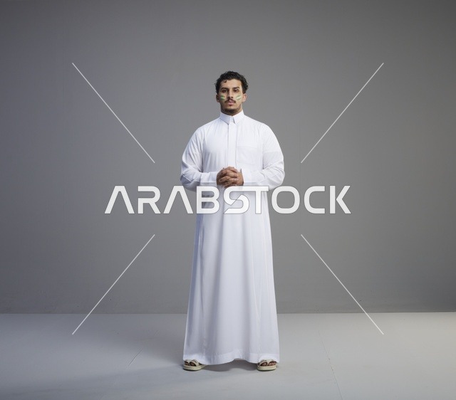 شاب سعودي بالثوب التقليدي يحتفل باليوم الوطني