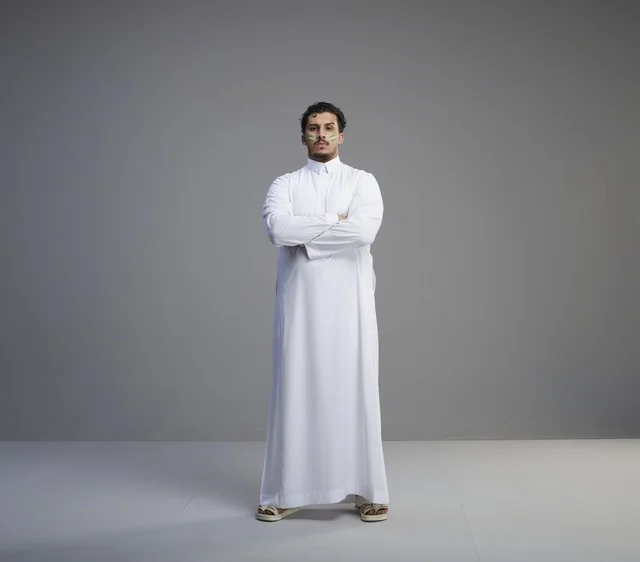 شاب سعودي بالثوب الأبيض مع رسم اليوم الوطني