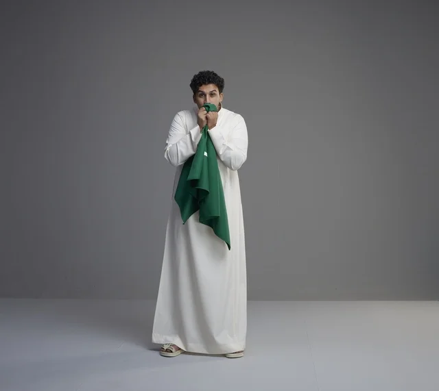 شاب سعودي يقبل العلم الوطني في الاستوديو