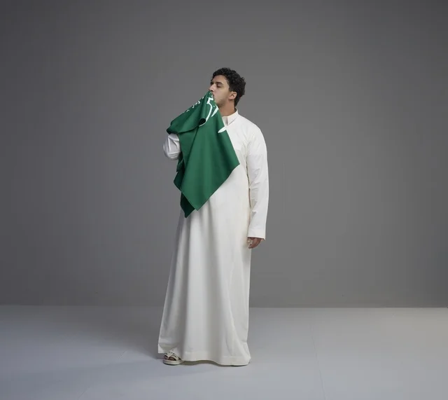 شاب سعودي يقبل العلم الوطني في الاستوديو