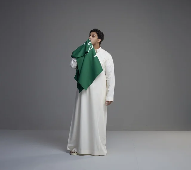Saudi Man in Thobe Kissing National Flag