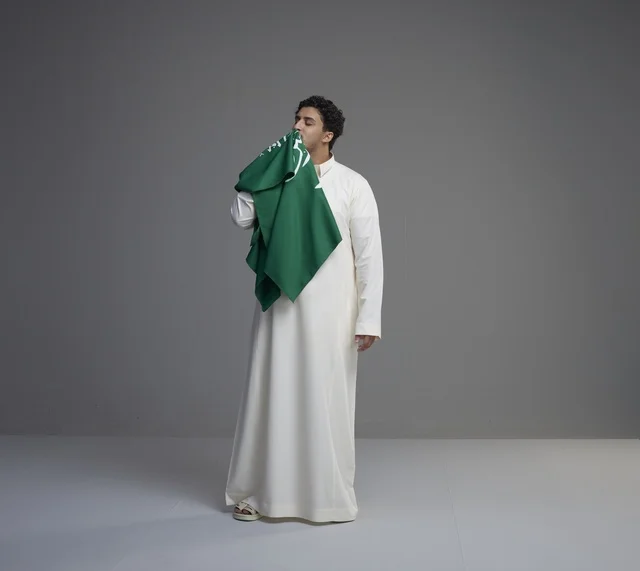 Saudi Man Kissing the National Flag in Studio Setting