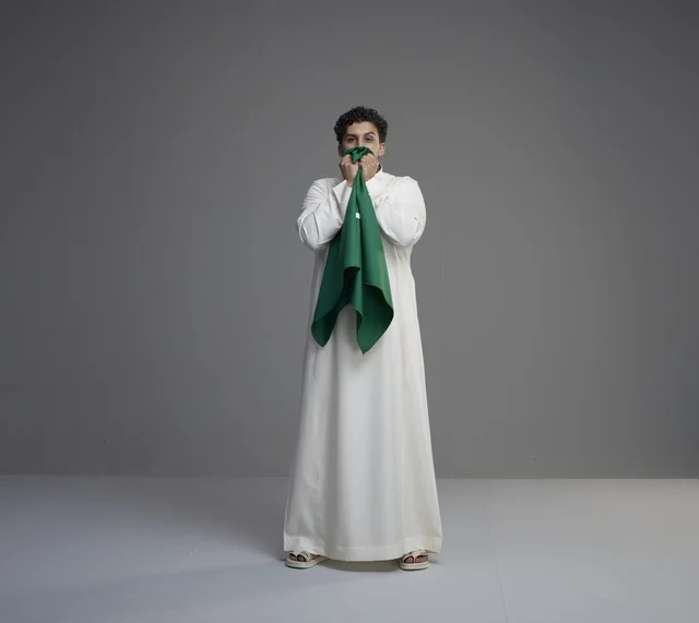 Saudi Man Kissing National Flag in Studio Portrait