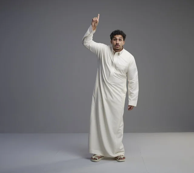 رجل سعودي بالثوب الأبيض يشير للأعلى في استوديو