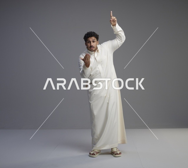 رجل سعودي بالثوب الأبيض التقليدي بحركات تعبيرية في الاستوديو