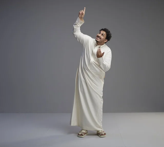 Saudi Man in Traditional White Thobe Pointing Up