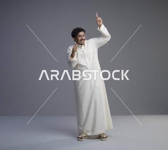رجل سعودي بالثوب الأبيض يشير للأعلى مع علامة التميز