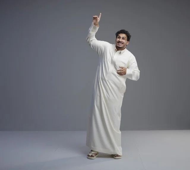 رجل سعودي بالثوب الأبيض التقليدي يشير للأعلى