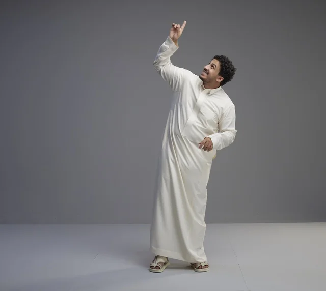 Saudi Man in White Thobe Pointing Up in Studio