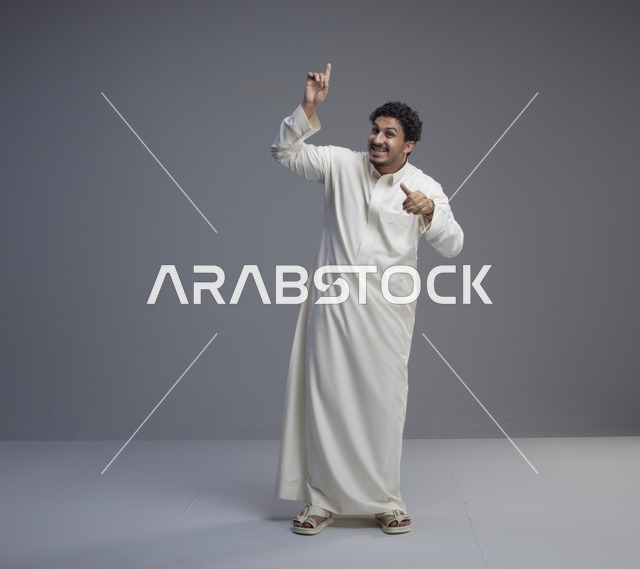رجل سعودي يشير للأعلى بالثوب الأبيض في الاستوديو