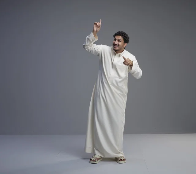 رجل سعودي يشير للأعلى بالثوب الأبيض في الاستوديو
