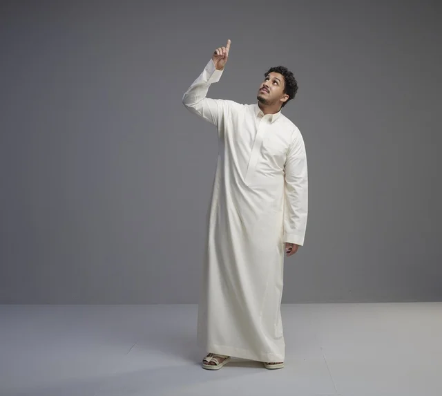 Saudi Man in Traditional White Thobe Pointing Up