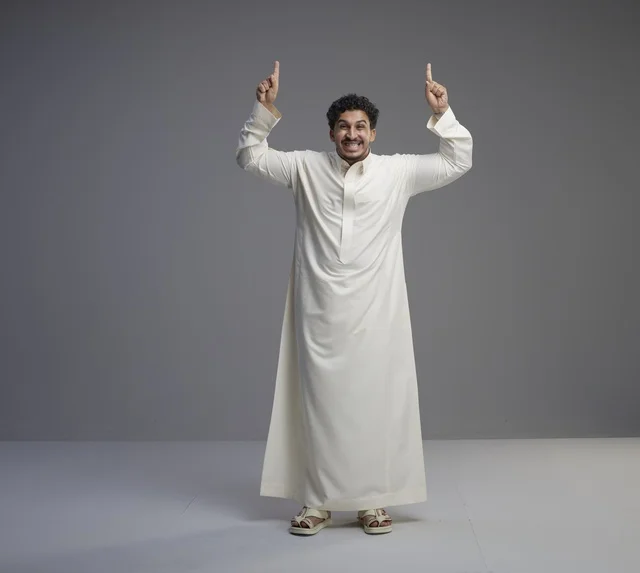 رجل سعودي بالثوب الأبيض يشير للأعلى في استوديو