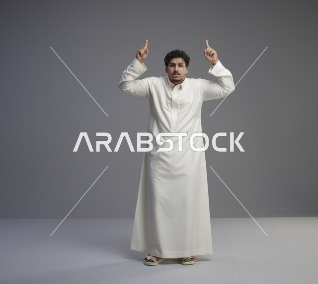 رجل سعودي بالثوب الأبيض يشير للأعلى
