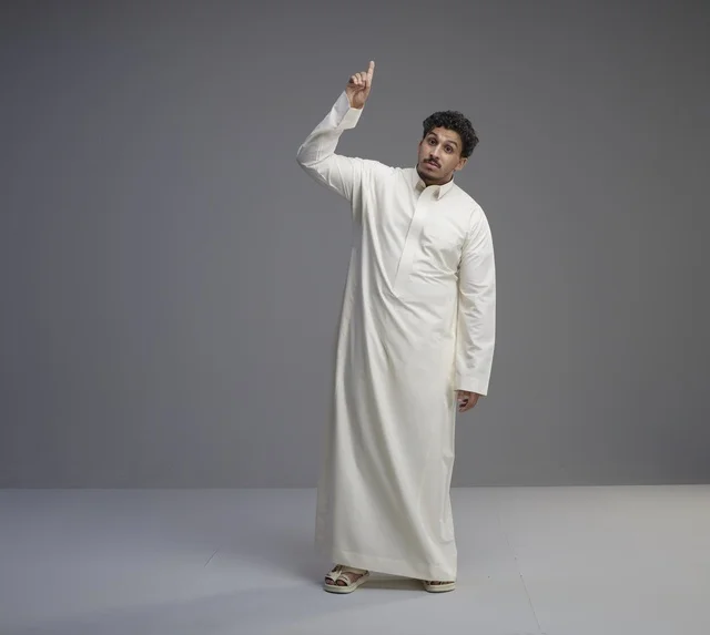 Saudi Man in Traditional White Thobe Pointing Upward