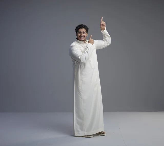 رجل سعودي بالثوب الأبيض التقليدي يشير للأعلى