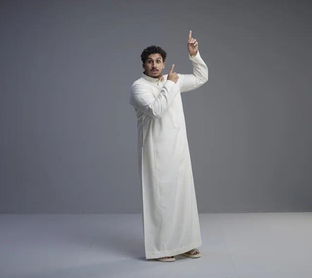 Saudi Man in White Thobe Pointing Up with Surprised Face