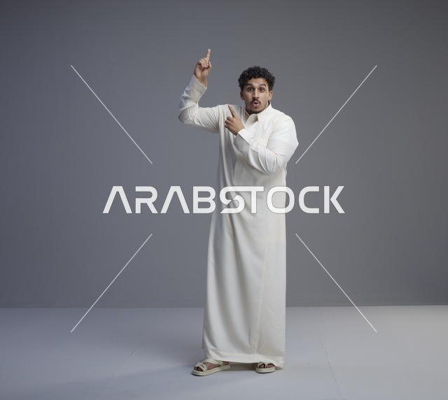 رجل سعودي بالثوب التقليدي يشير للأعلى بدهشة