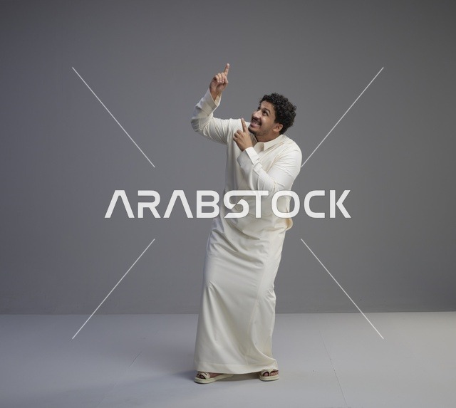 رجل سعودي بالثوب التقليدي يشير للأعلى