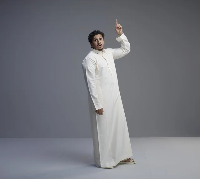 رجل سعودي بالثوب الأبيض يشير للأعلى بدهشة