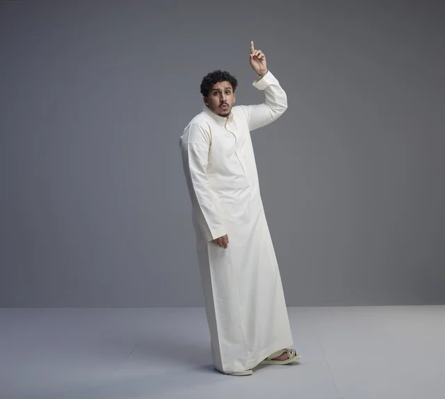 Saudi Man in White Thobe Pointing Up in Studio