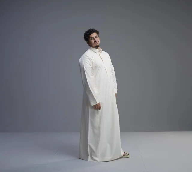 رجل سعودي يرتدي الثوب الأبيض التقليدي في استوديو