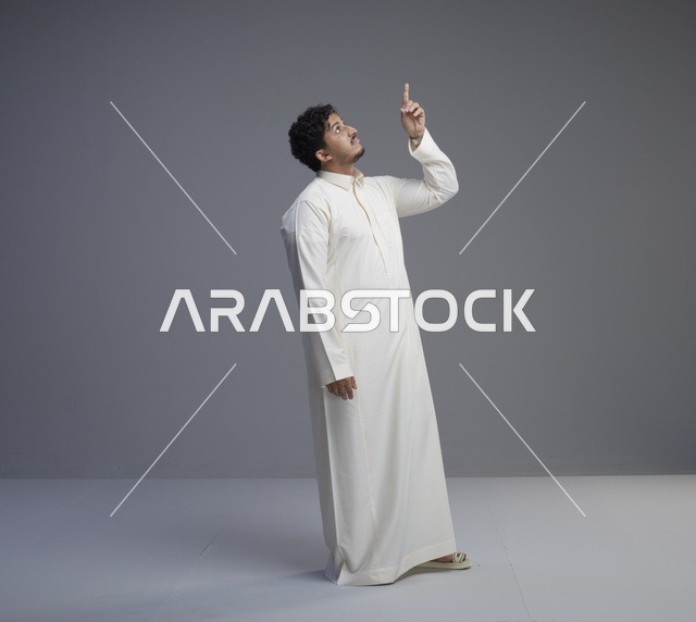 رجل سعودي بالثوب الأبيض يشير للأعلى
