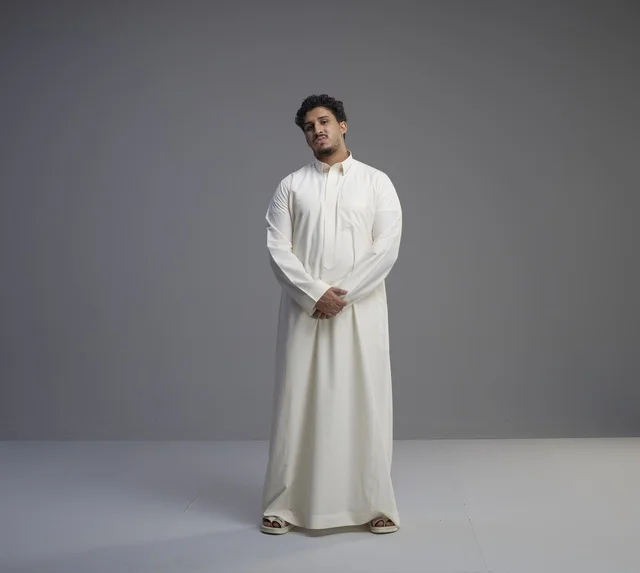 رجل سعودي بالثوب الأبيض التقليدي في استوديو تصوير