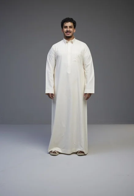رجل سعودي بالثوب الأبيض التقليدي في الاستوديو