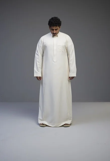 رجل سعودي بالثوب الأبيض التقليدي في استوديو