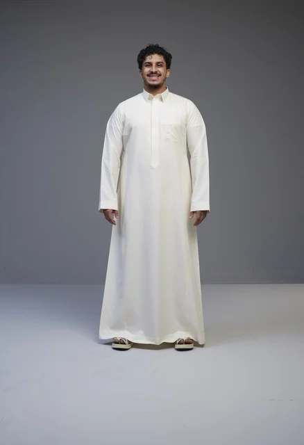 رجل سعودي يرتدي الثوب الأبيض التقليدي في الاستوديو