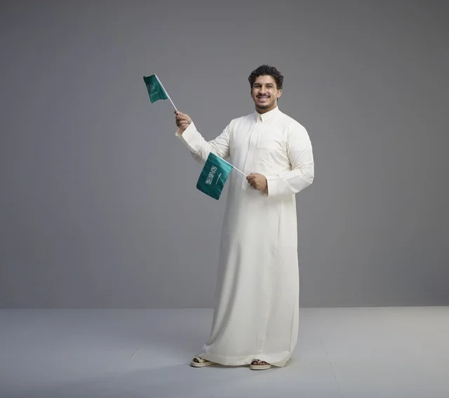 Smiling Saudi Man Holding Saudi Arabia Flags in Studio