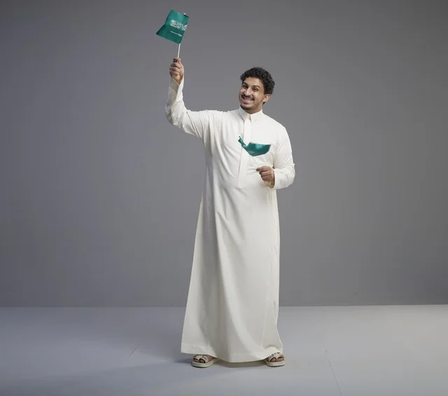 Smiling Saudi Man Holding National Flag in Studio