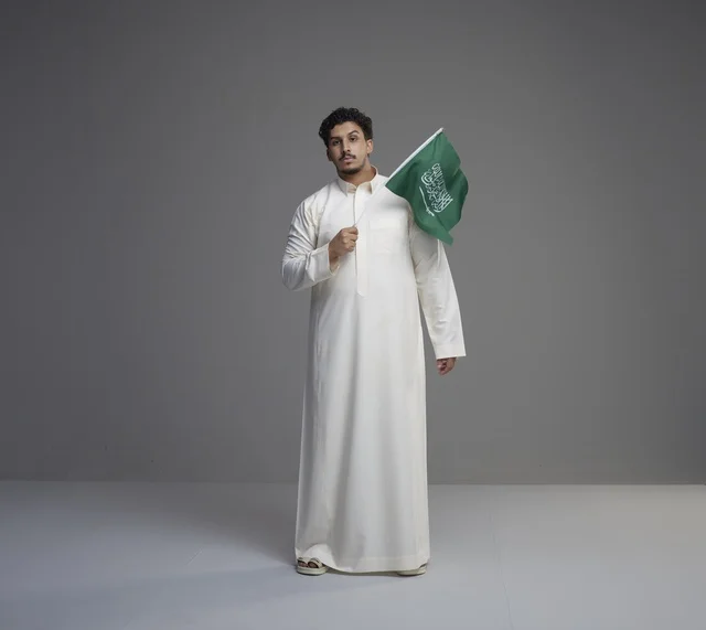 Saudi Man in Thobe Holding Saudi Arabia National Flag