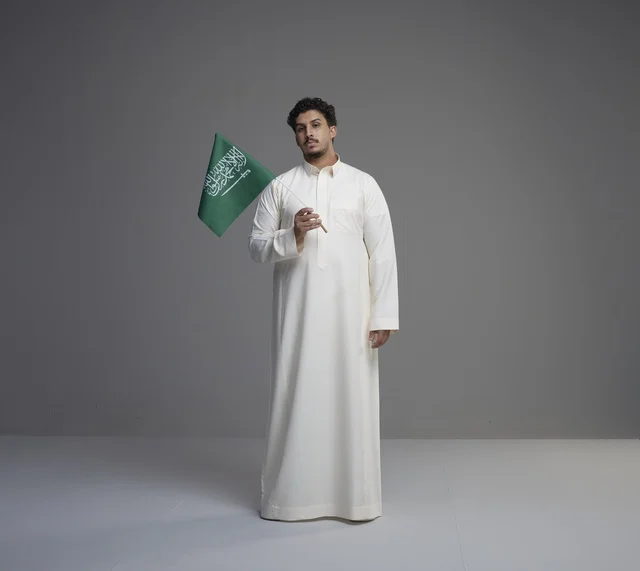 شاب سعودي يحمل علم السعودية في الاستوديو