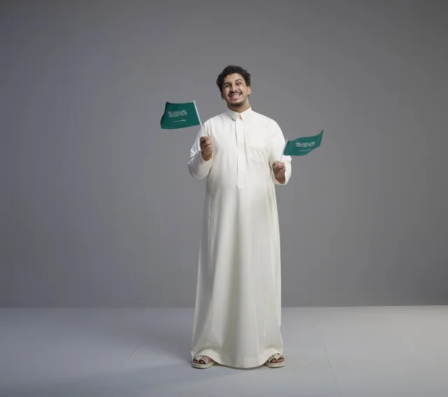 Smiling Saudi Man in Thobe Holding Saudi National Flags
