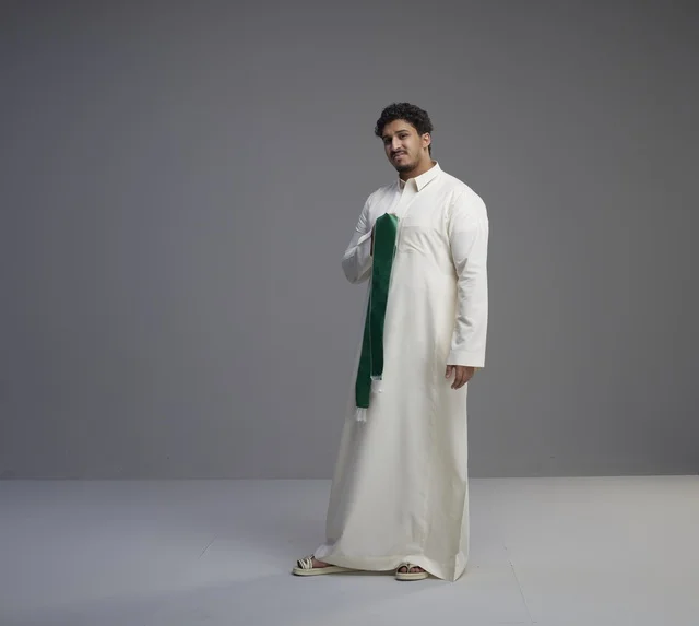 Saudi Man in Traditional Thobe Holding Green National Scarf