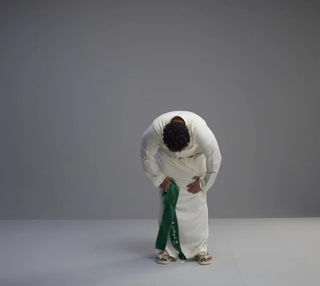 رجل سعودي بالثوب يحمل الوشاح الوطني في استوديو رجل سعودي بالثوب يحمل الوشاح الوطني في استوديو