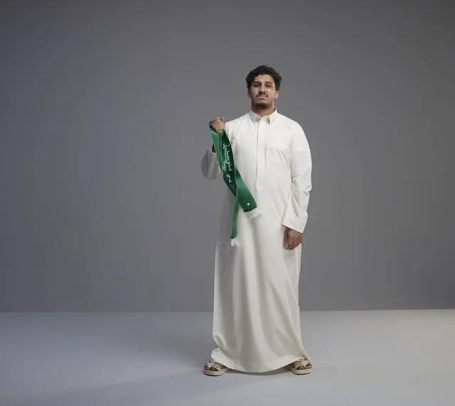Saudi Man in White Thobe Holding Green National Scarf