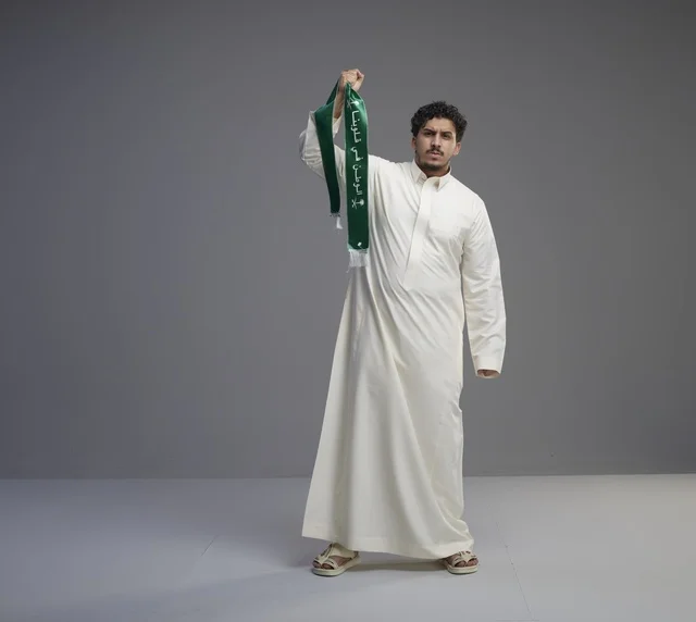 Saudi Man Holding Green National Scarf in Studio