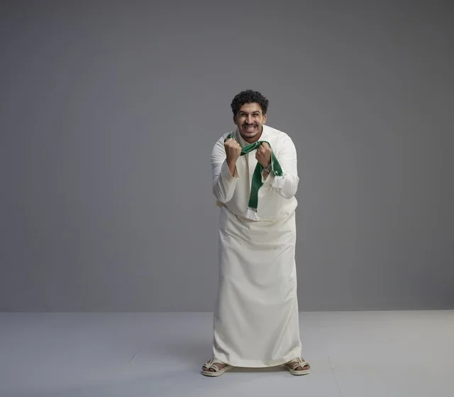 Saudi Man Holding Green National Scarf in Studio
