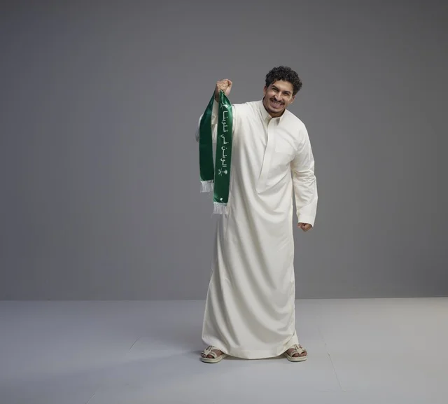 رجل سعودي يحمل وشاحاً وطنياً في استوديو