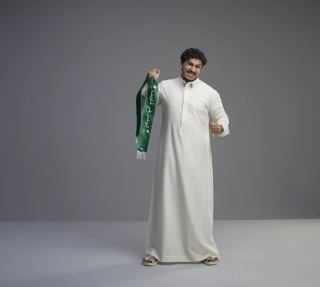 رجل سعودي يحمل وشاح اليوم الوطني في الاستوديو