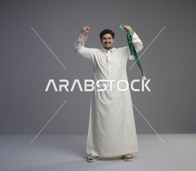 رجل سعودي يحتفل بوشاح وطني أخضر في الاستوديو