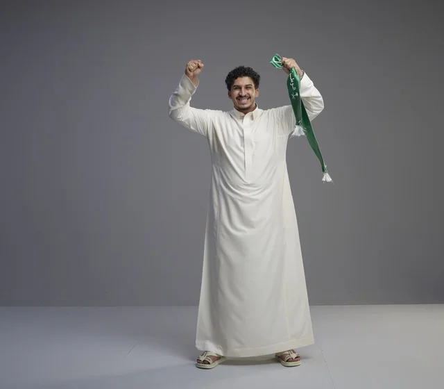 Saudi Man Celebrating with Green National Scarf in Studio