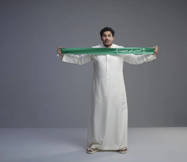Saudi Man Holding Green National Scarf in Studio