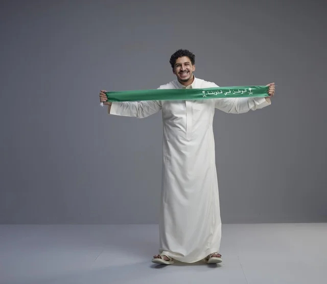 رجل سعودي يحمل وشاح الوطن الأخضر في الاستوديو رجل سعودي يحمل وشاح الوطن الأخضر في الاستوديو