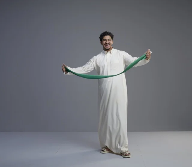 Saudi Man Holding Green National Scarf in Studio