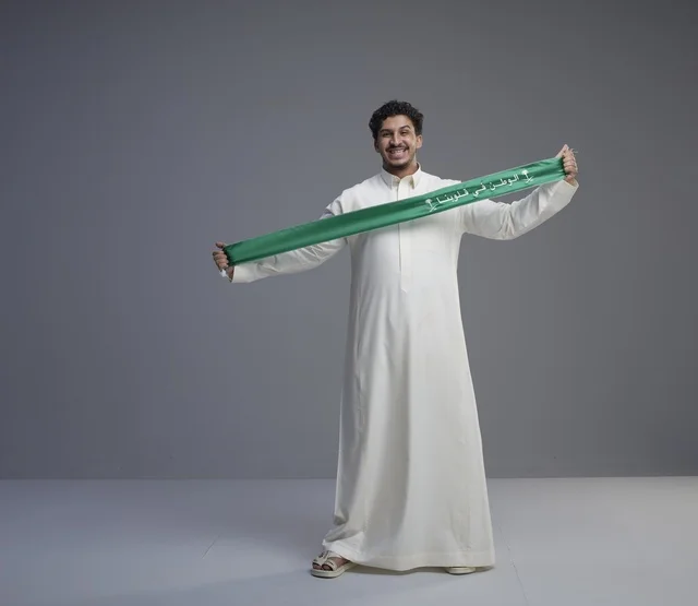 Saudi Man Holding Green National Scarf in Studio