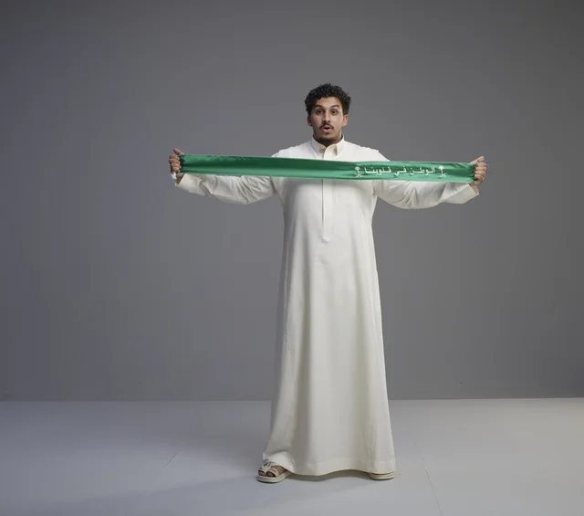 Saudi Man Holding Green National Scarf in Studio